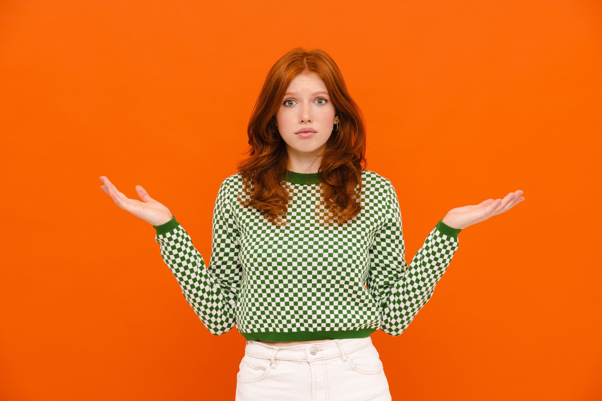 1920-confused-ginger-woman-in-plaid-sweater-holding-copyspace