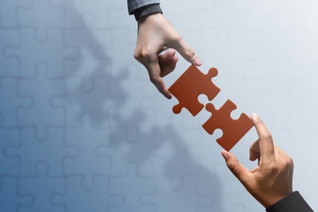 640-business-partnership-or-teamwork-concept-hands-of-two-people-try-to-fit-or-conncet-jigsaw-puzzle-piece-together-top-view-1